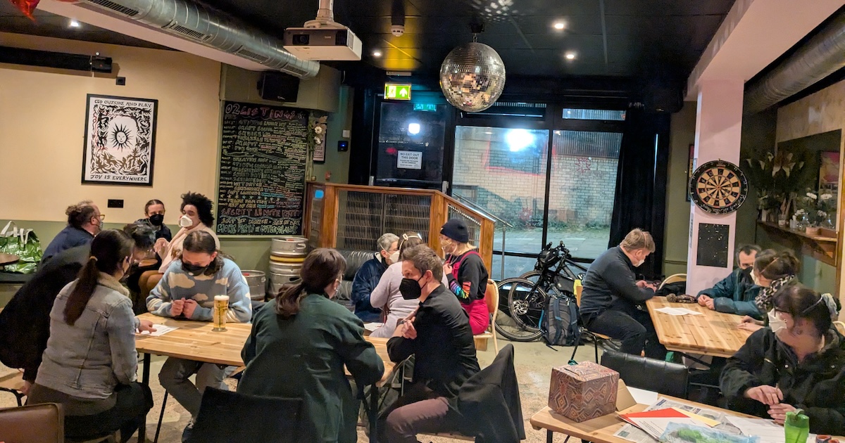 Groups of masked people sat at tables in Gut Level